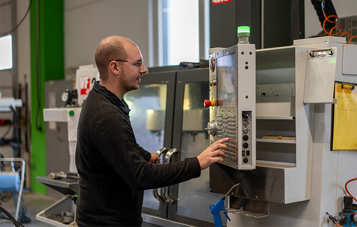 Mitarbeiter bedient Maschine in der Produktionshalle